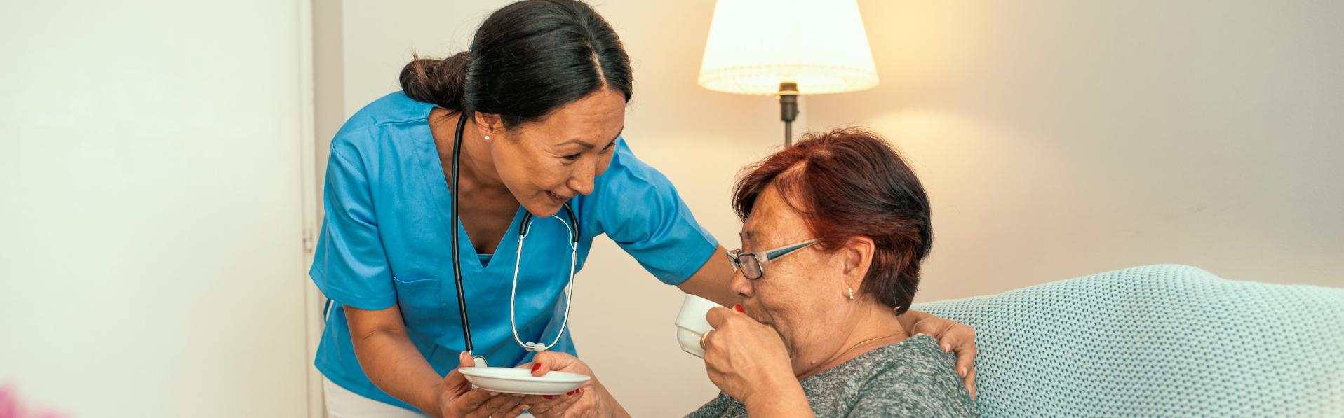 A caregiver attending to her elderly patient.